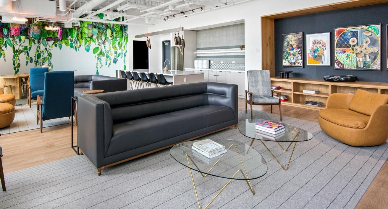 A vibrant resident lounge at Spoke Apartments in Chicago, featuring diverse seating areas and unique artwork
