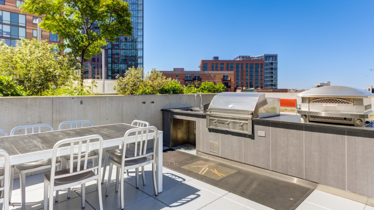A spacious rooftop dining and grill area at Spoke Apartments in Chicago, ideal for entertaining with city views