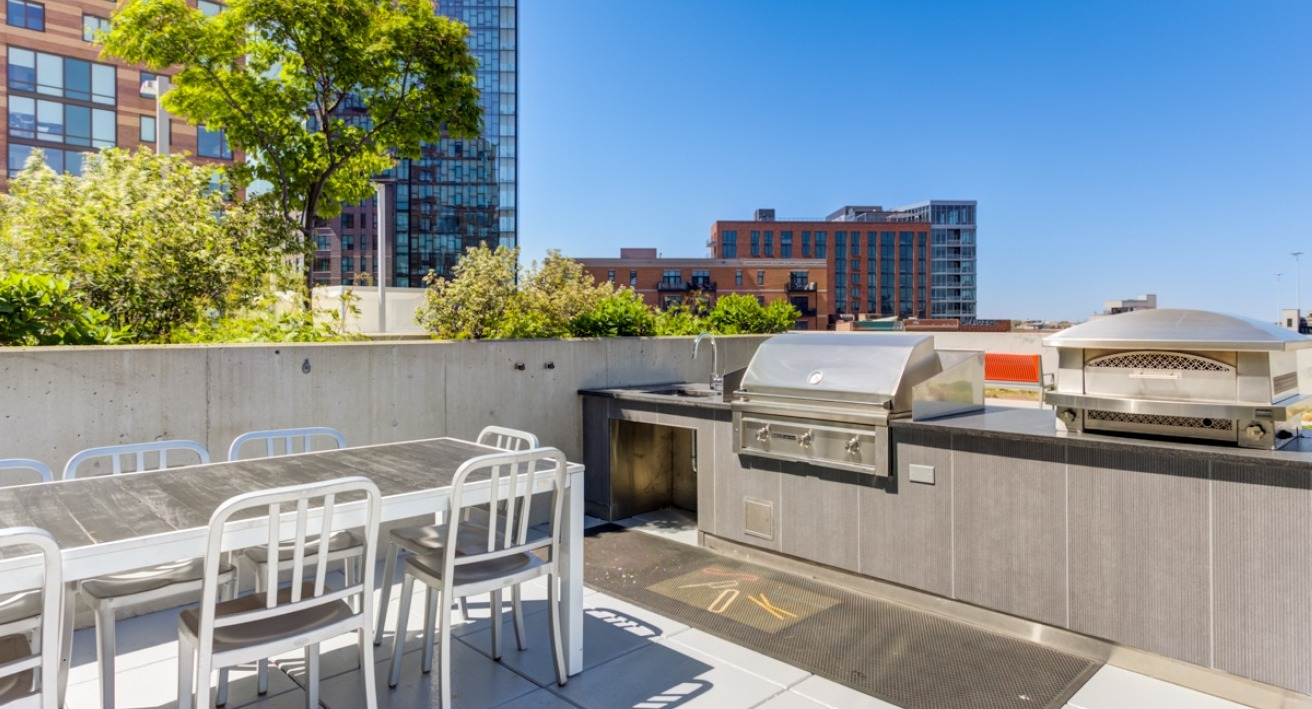 A spacious rooftop dining and grill area at Spoke Apartments in Chicago, ideal for entertaining with city views