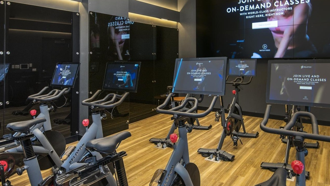 A state-of-the-art fitness center at Spoke Apartments in Chicago, featuring multiple Peloton bikes and large screens