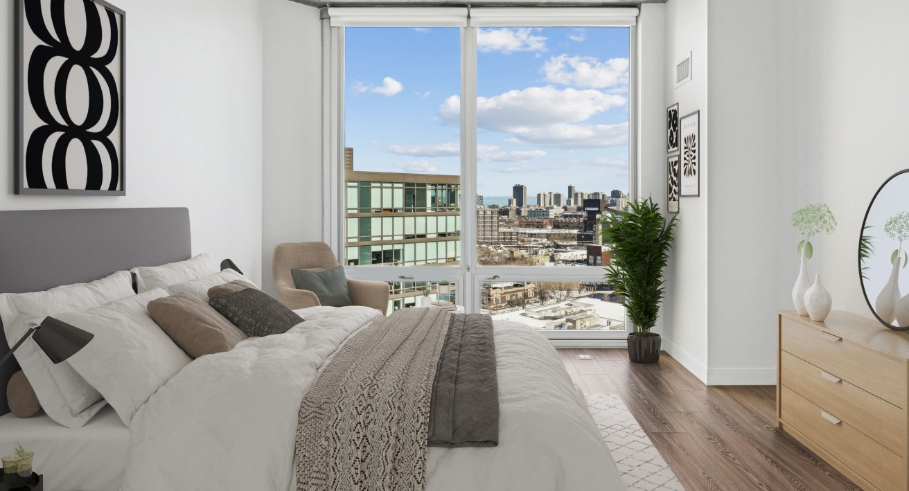 A stylish bedroom at Spoke Apartments in Chicago, with a large window offering city views and contemporary decor