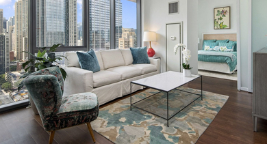 Spacious living room at State & Chestnut in Chicago, featuring a comfortable sofa, stylish coffee table, and stunning panoramic city views