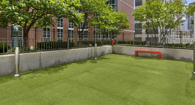 Convenient outdoor dog park at State & Chestnut in Chicago, featuring artificial turf and ample space for pets to play