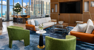 Elegant resident lounge at State & Chestnut in Chicago, featuring comfortable seating, a large TV, and expansive windows with city and lake views