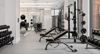 Comprehensive weight room at State & Chestnut in Chicago, featuring free weights, benches, and strength training equipment