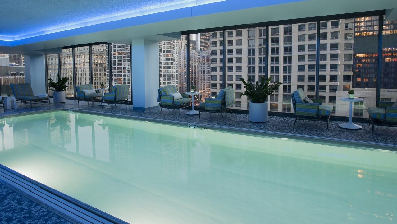 Luxurious indoor swimming pool at State and Grand Apartments in Chicago, featuring comfortable lounge seating and city views