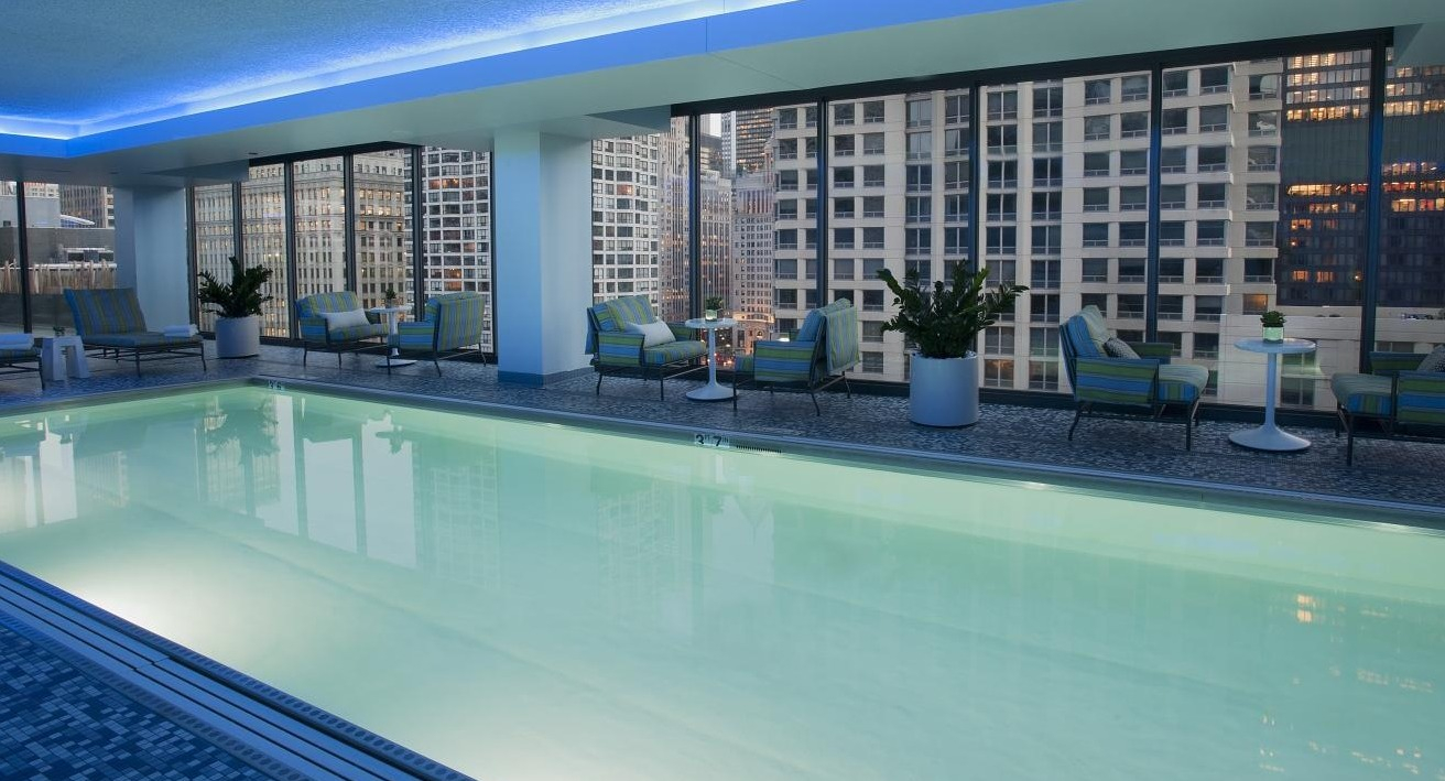 Luxurious indoor swimming pool at State and Grand Apartments in Chicago, featuring comfortable lounge seating and city views