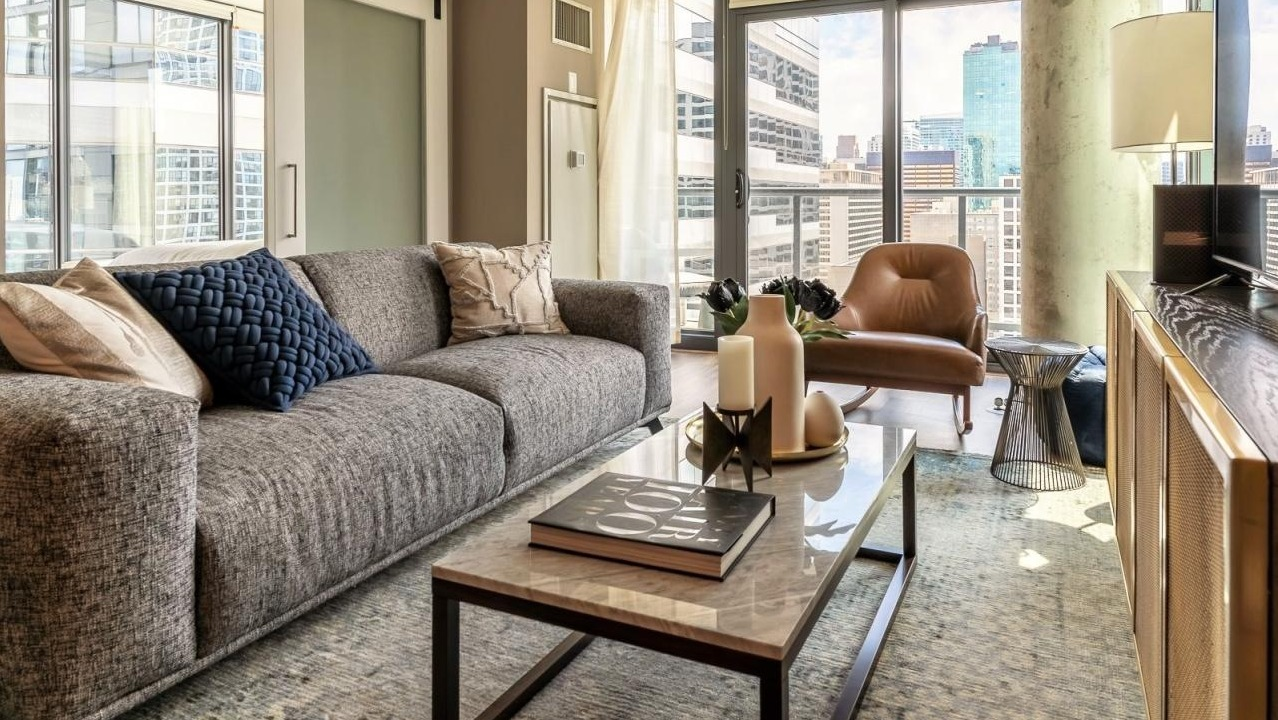 Modern living room at State and Grand Apartments in Chicago, featuring a comfortable sofa, stylish coffee table, and unique barn door