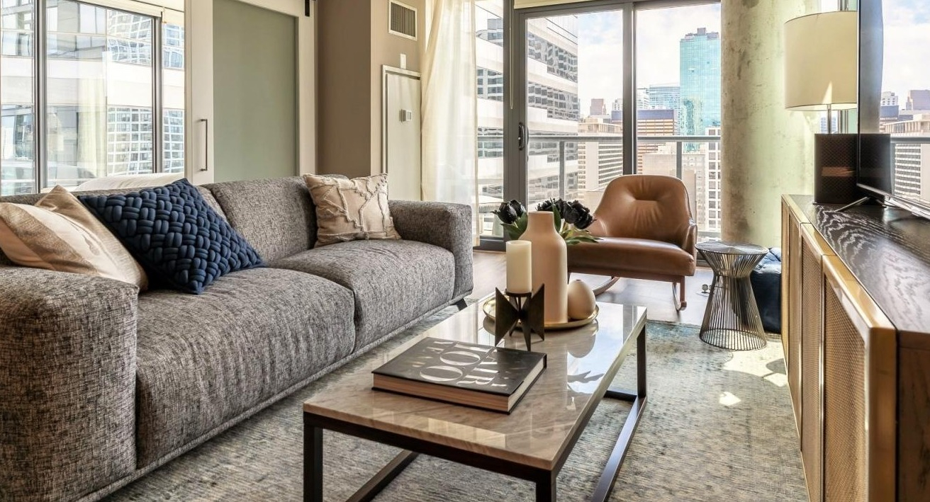 Modern living room at State and Grand Apartments in Chicago, featuring a comfortable sofa, stylish coffee table, and unique barn door