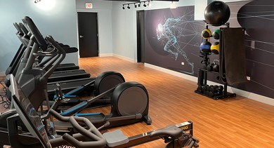 Modern fitness center cardio area with treadmills, ellipticals, and spin bikes at The Aberdeen West Loop Luxury Apartments