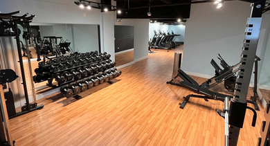 Comprehensive view of the modern fitness center with both cardio and weight training equipment at The Aberdeen West Loop Luxury Apartments
