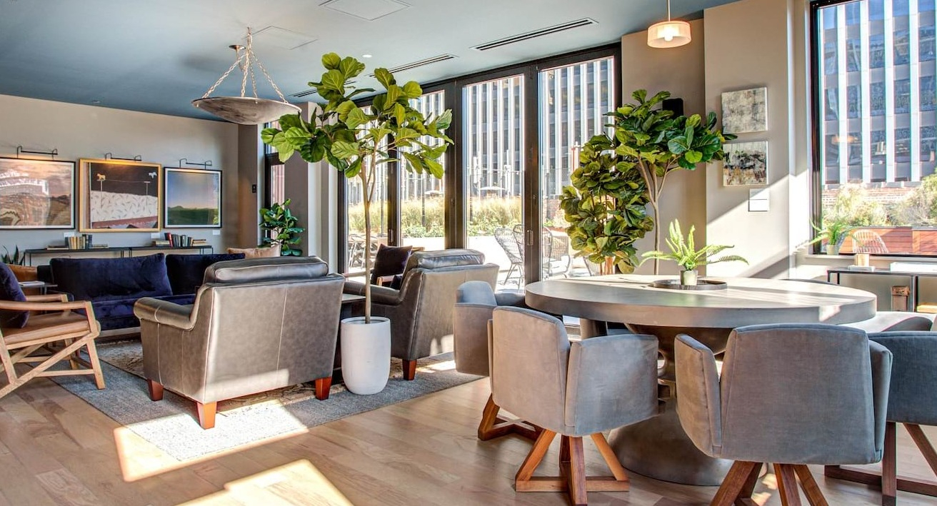 Elegant community space at The Alfred Apartments in Chicago, with comfortable seating, lush plants, and large windows