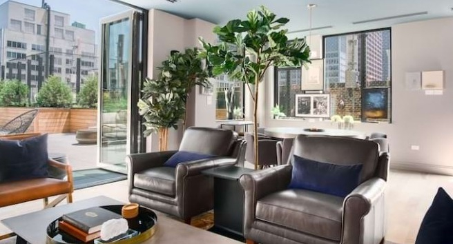Seamless indoor-outdoor lounge at The Alfred Apartments in Chicago, with comfortable seating and access to a rooftop patio