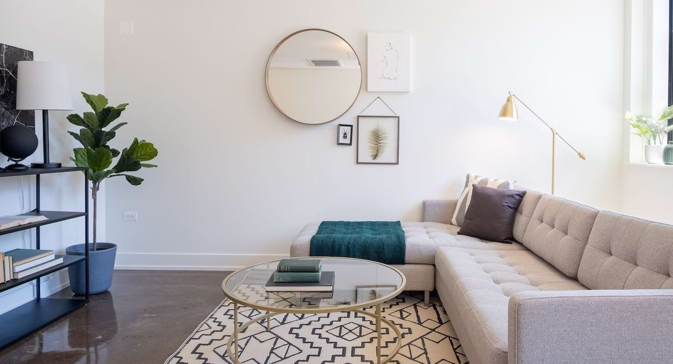 Modern living room at The Alfred Apartments in Chicago, featuring a comfortable sectional sofa, geometric rug, and stylish decor