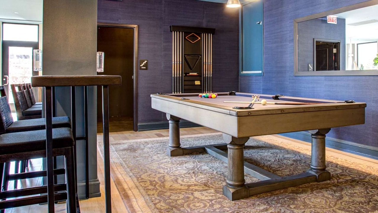 Resident game room at The Alfred Apartments in Chicago, featuring a billiards table, high-top seating, and stylish decor