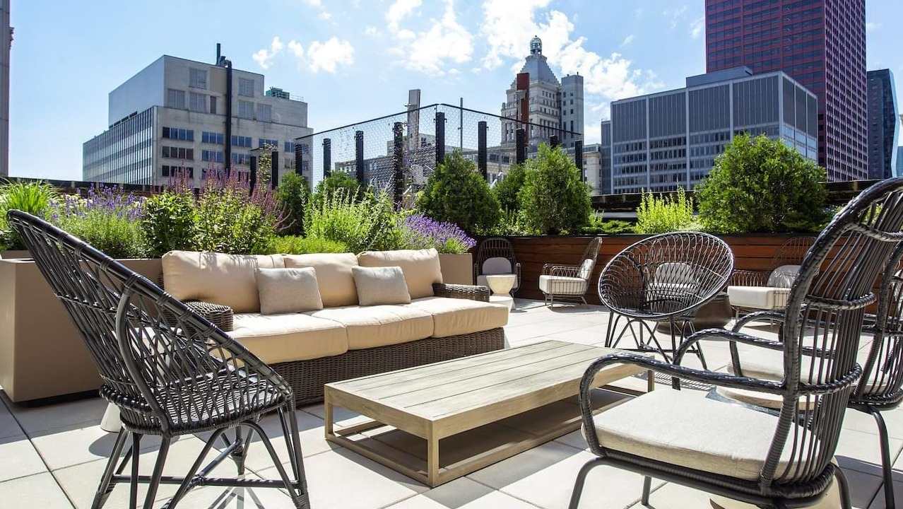 Rooftop lounge area at The Alfred Apartments in Chicago, offering comfortable seating surrounded by greenery and city views