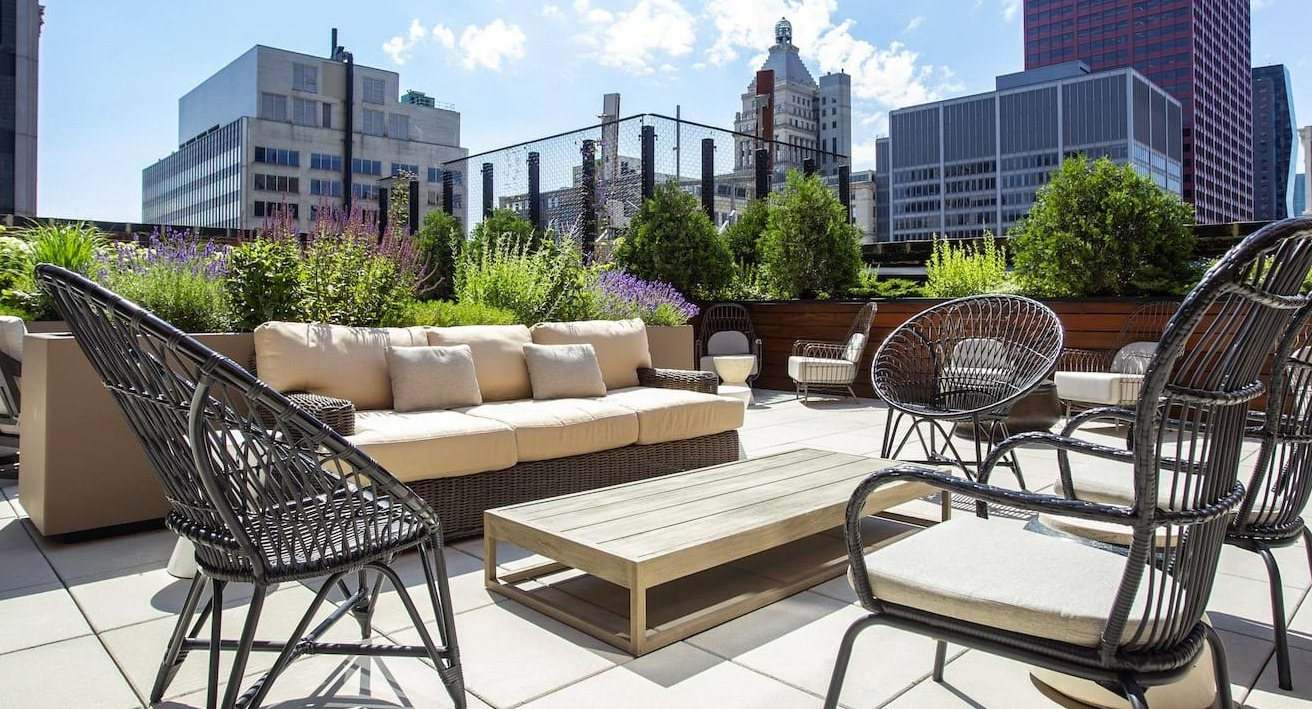 Rooftop lounge area at The Alfred Apartments in Chicago, offering comfortable seating surrounded by greenery and city views