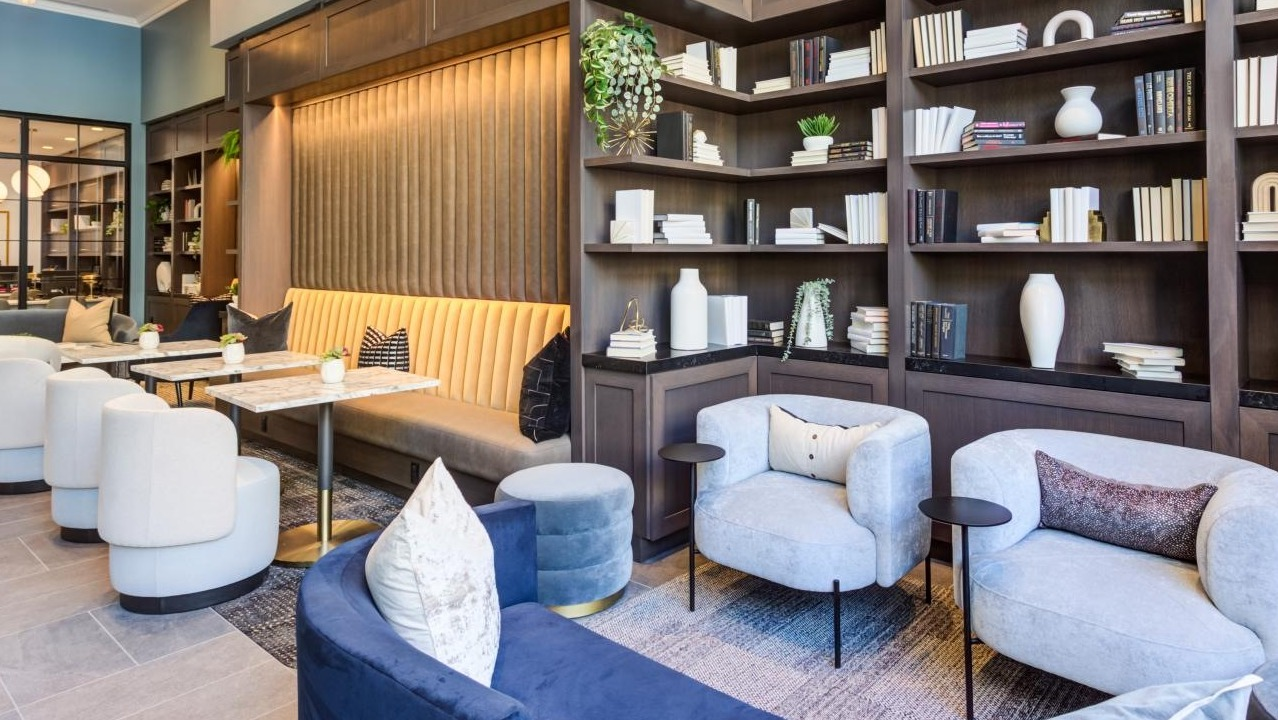 Luxurious clubroom with comfortable sofas, elegant armchairs, and extensive bookshelves, creating a refined atmosphere at The Bernardin Apartments in Chicago