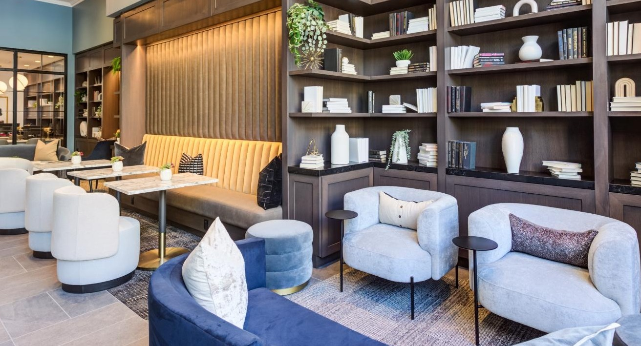 Luxurious clubroom with comfortable sofas, elegant armchairs, and extensive bookshelves, creating a refined atmosphere at The Bernardin Apartments in Chicago