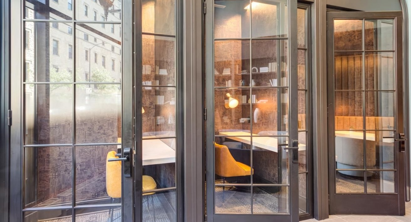 Modern co-working area with individual glass-enclosed pods, offering private and quiet workspaces at The Bernardin Apartments in Chicago