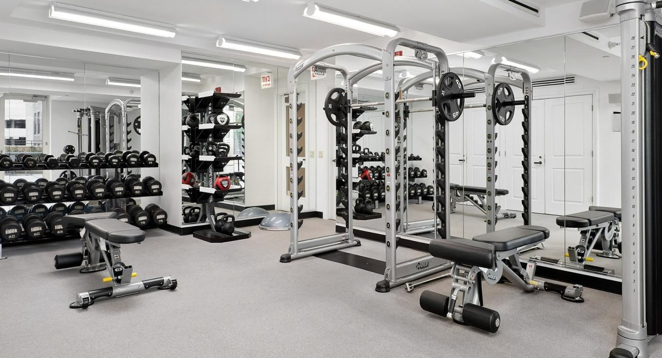 Spacious fitness center with a variety of weight machines, free weights, and ample space for strength training at The Bernardin Apartments in Chicago