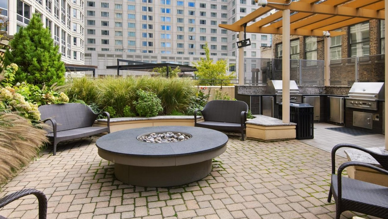 Lush outdoor patio area with grilling stations, a fire pit, and comfortable seating, ideal for entertaining at The Bernardin Apartments in Chicago