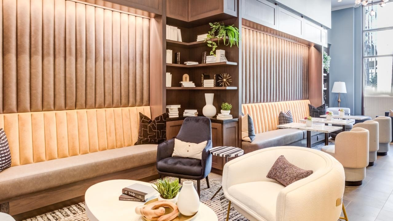 Warm and inviting resident lounge with plush seating, built-in bookshelves, and elegant decor, perfect for socializing at The Bernardin Apartments in Chicago