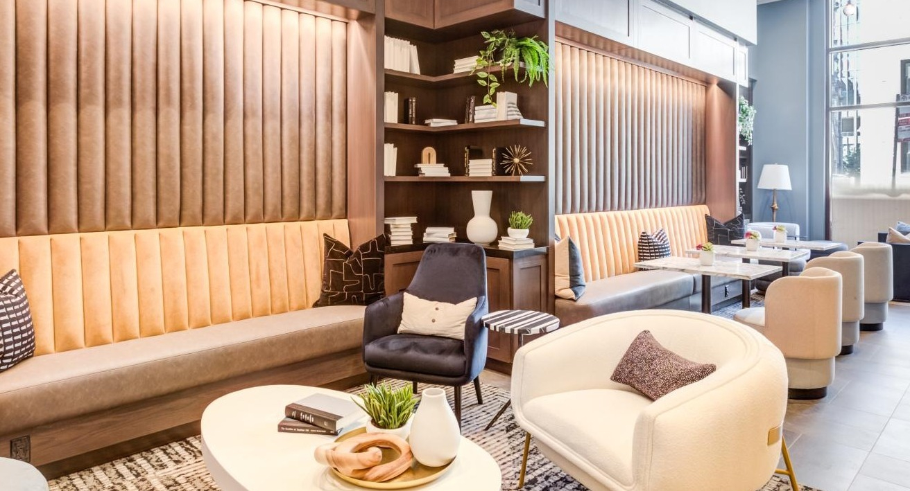 Warm and inviting resident lounge with plush seating, built-in bookshelves, and elegant decor, perfect for socializing at The Bernardin Apartments in Chicago