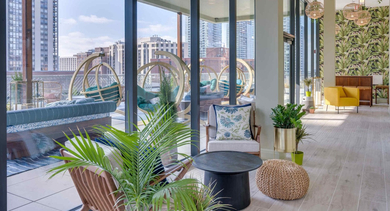 Luxurious rooftop lounge with a long fire pit, comfortable outdoor seating, and scenic Chicago skyline views at The Clark
