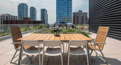 Expansive rooftop terrace with outdoor dining furniture and stunning city views at The Clark Apartments in Chicago