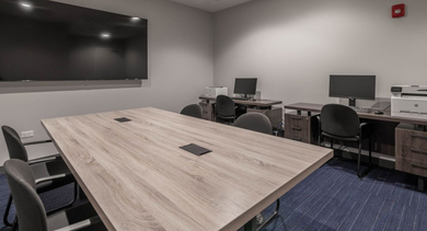 Functional business center with a large conference table, computers, and printers, ideal for remote work at The Clark Apartments in Chicago