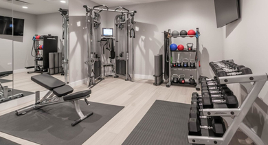 Well-equipped fitness center featuring various weight training machines, free weights, and gym accessories at The Clark Apartments in Chicago