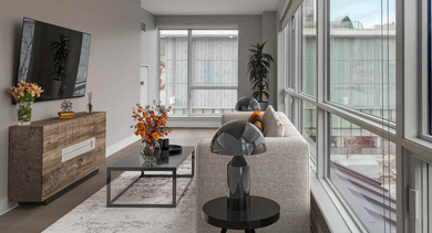 Bright living room with comfortable seating, modern decor, and expansive windows offering natural light at The Clark Apartments in Chicago