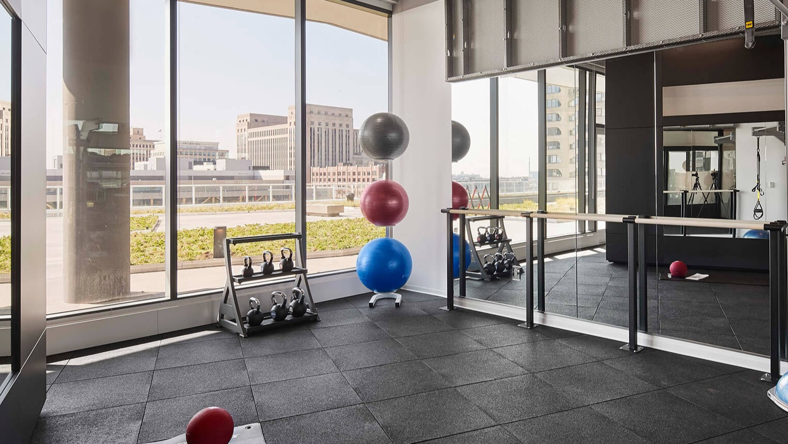 Well-equipped fitness studio with mirrors, exercise balls, and free weights, perfect for yoga or functional training at The Cooper in Chicago