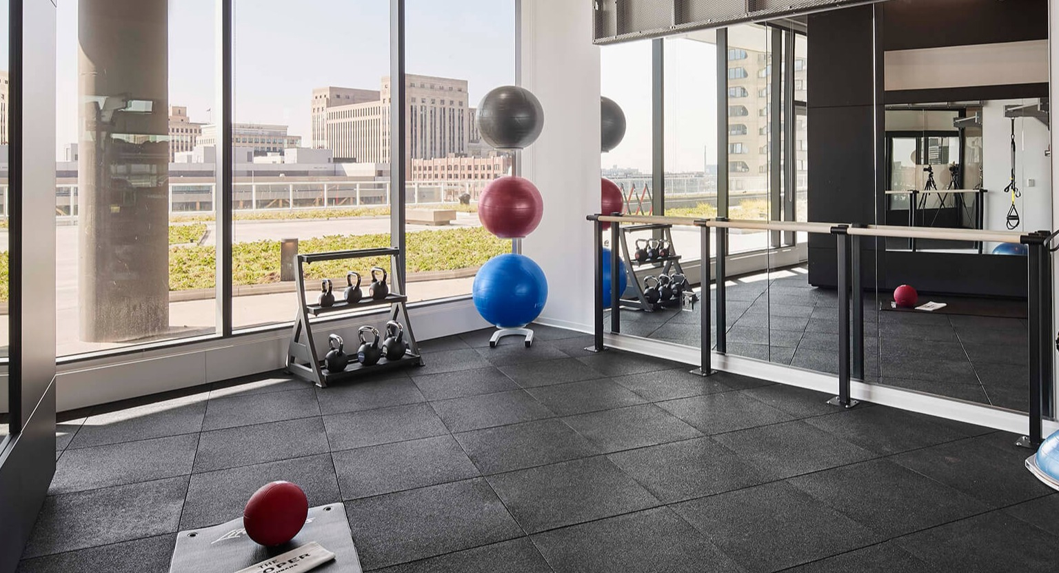 Well-equipped fitness studio with mirrors, exercise balls, and free weights, perfect for yoga or functional training at The Cooper in Chicago