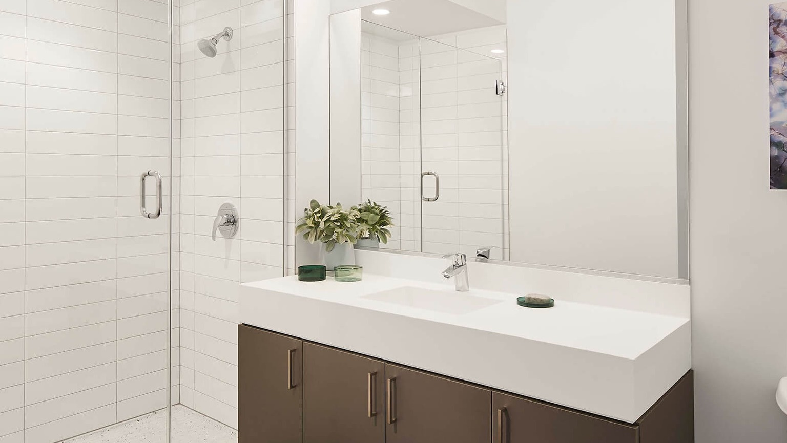Modern bathroom featuring a spacious vanity, large mirror, and a sleek walk-in shower with white subway tiles at The Cooper in Chicago