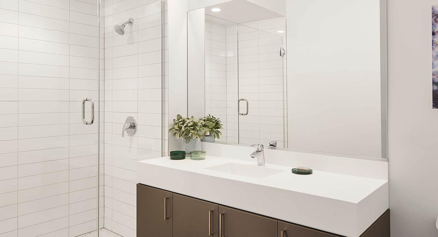 Modern bathroom featuring a spacious vanity, large mirror, and a sleek walk-in shower with white subway tiles at The Cooper in Chicago