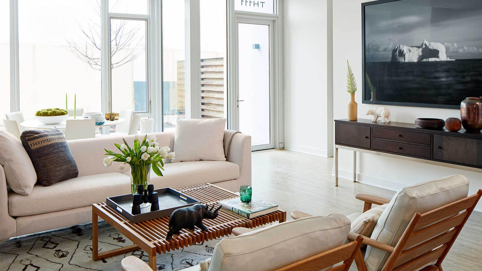 Bright and spacious living and dining area with large windows, stylish furniture, and contemporary decor at The Cooper apartments in Chicago