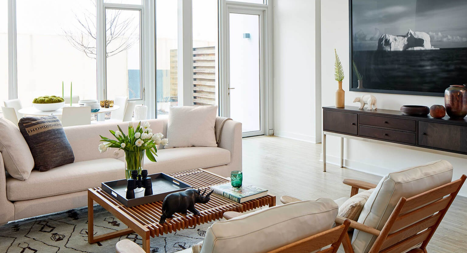 Bright and spacious living and dining area with large windows, stylish furniture, and contemporary decor at The Cooper apartments in Chicago