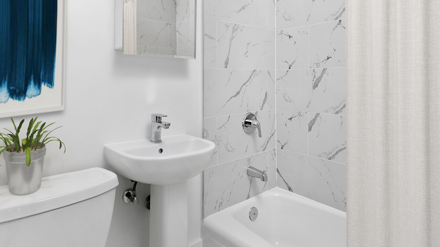 Beautiful bathroom with marble-patterned tiles, a pedestal sink, and a clean white bathtub at The Deco North Lake Shore in Chicago