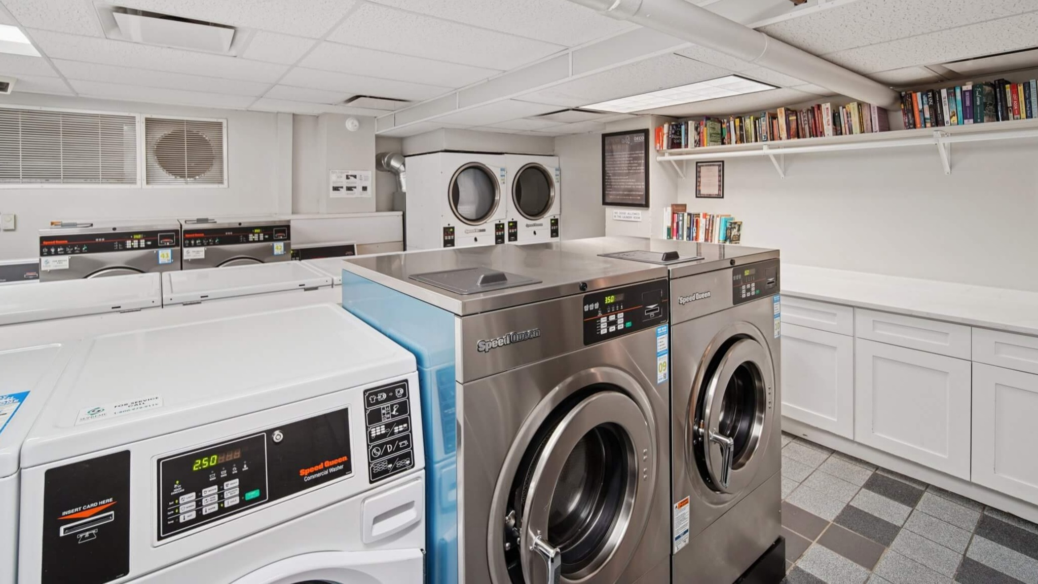 Modern and clean community laundry room with multiple washers and dryers, plus shelving for convenience at The Deco North Lake Shore in Chicago