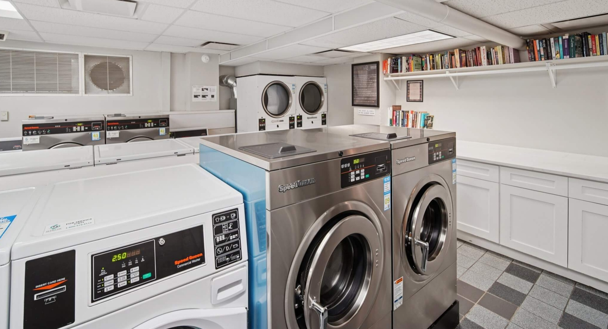 Modern and clean community laundry room with multiple washers and dryers, plus shelving for convenience at The Deco North Lake Shore in Chicago