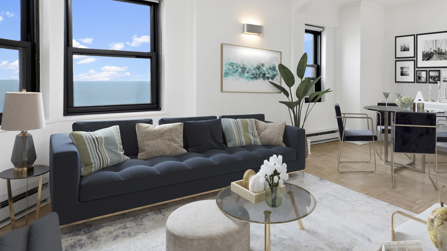 Open living and dining area with a navy sofa, dining table, and large windows offering expansive views at The Deco North Lake Shore in Chicago