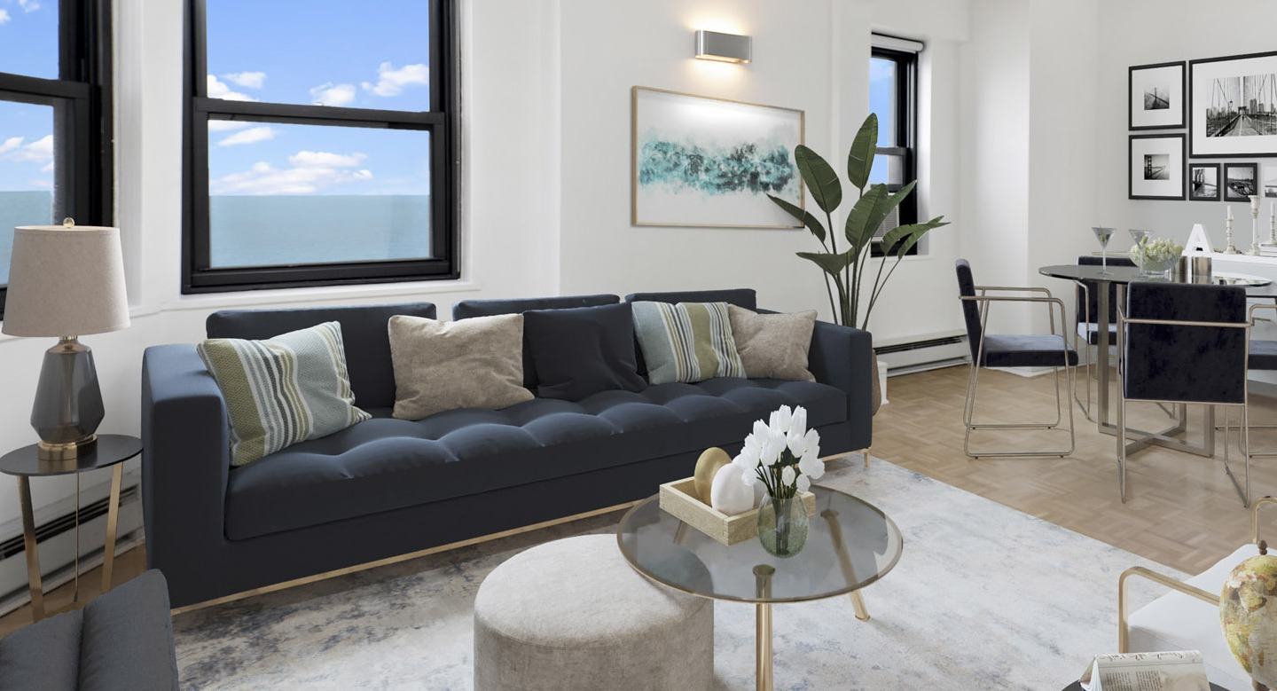 Open living and dining area with a navy sofa, dining table, and large windows offering expansive views at The Deco North Lake Shore in Chicago
