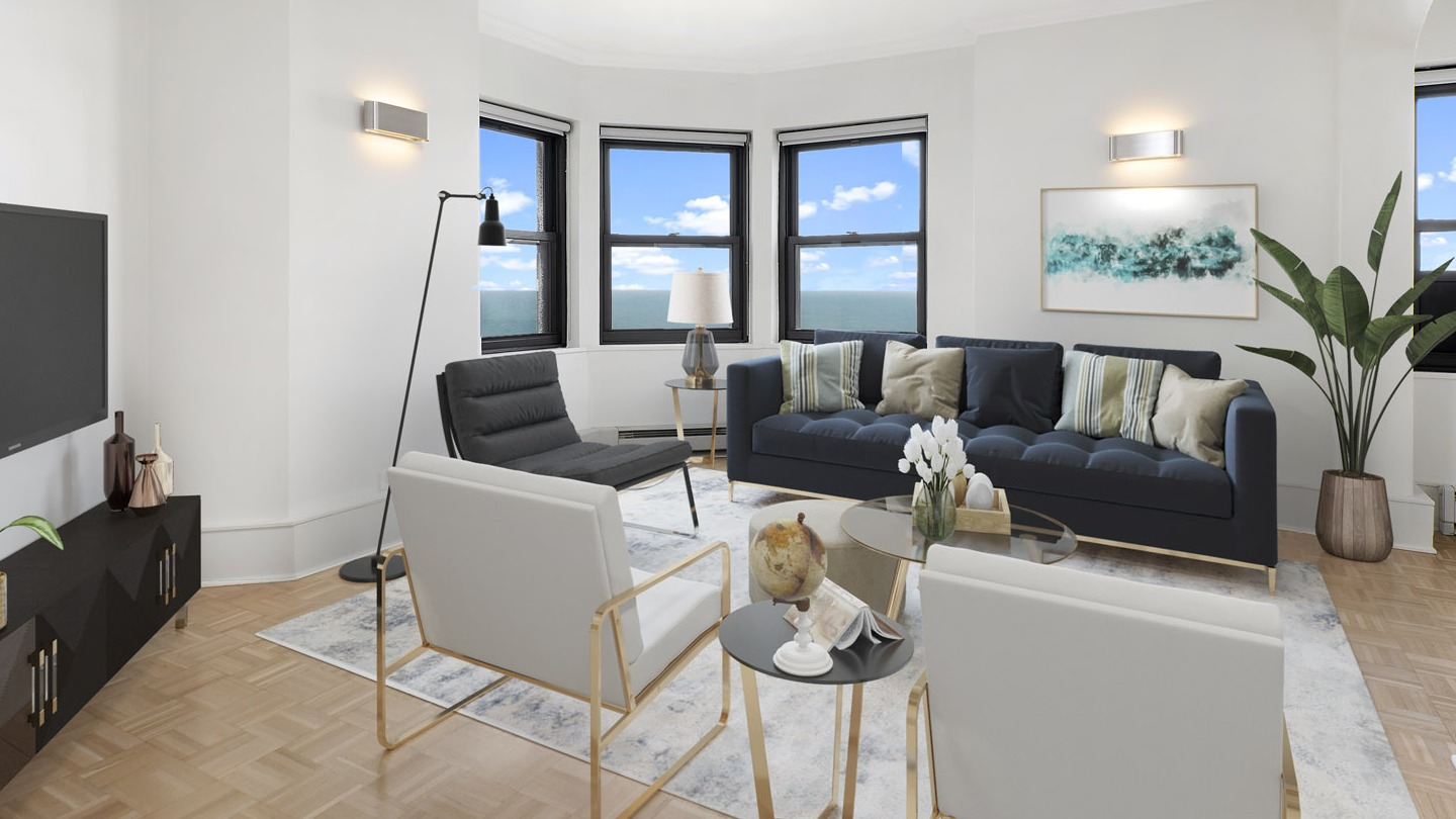 Bright modern living room with a navy sofa, white armchairs, sleek media console, and large windows at The Deco North Lake Shore in Chicago