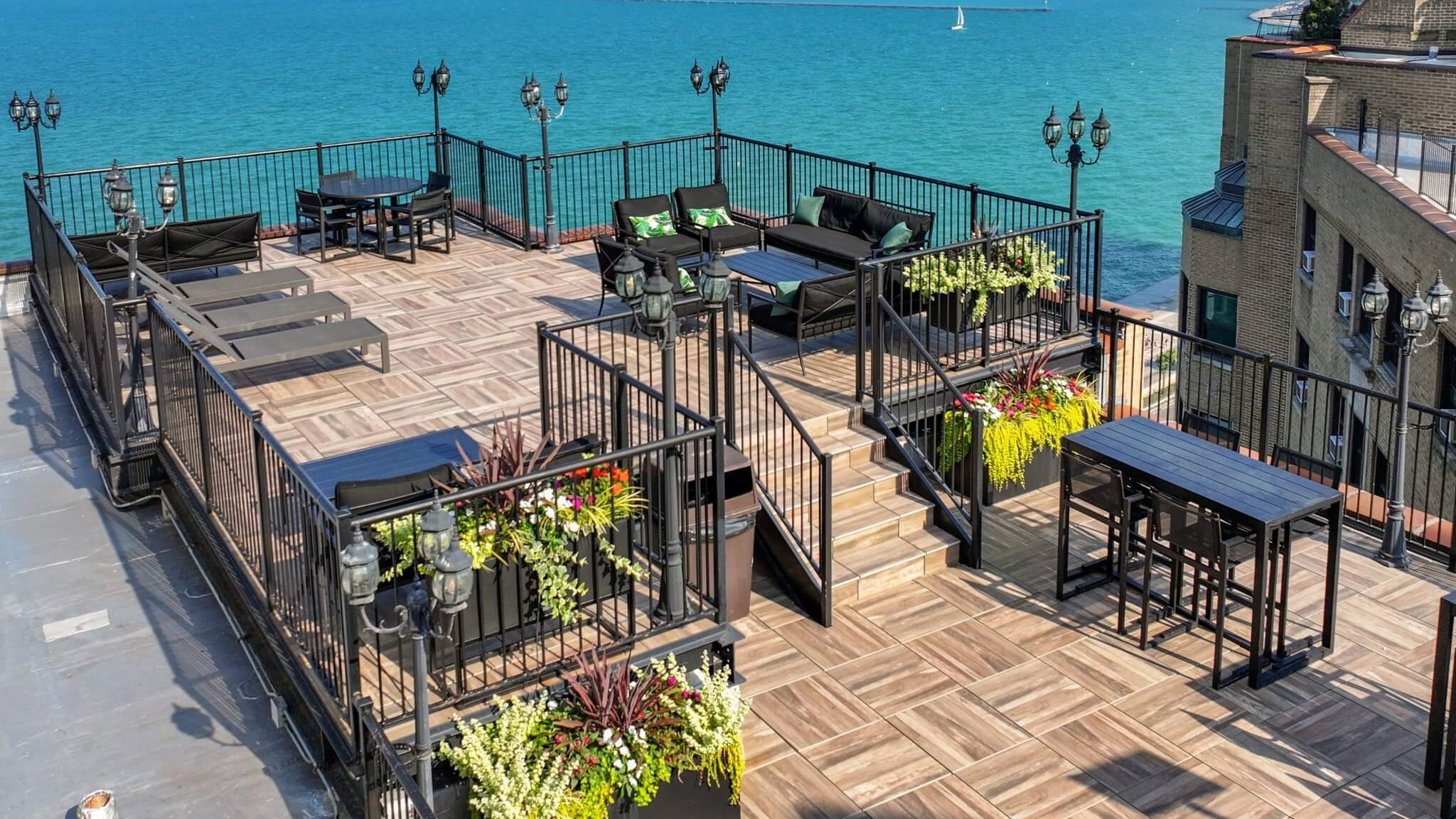 Stunning panoramic lakefront terrace with ample seating, dining tables, and breathtaking views of Lake Michigan and the city skyline at The Deco North Lake Shore in Chicago
