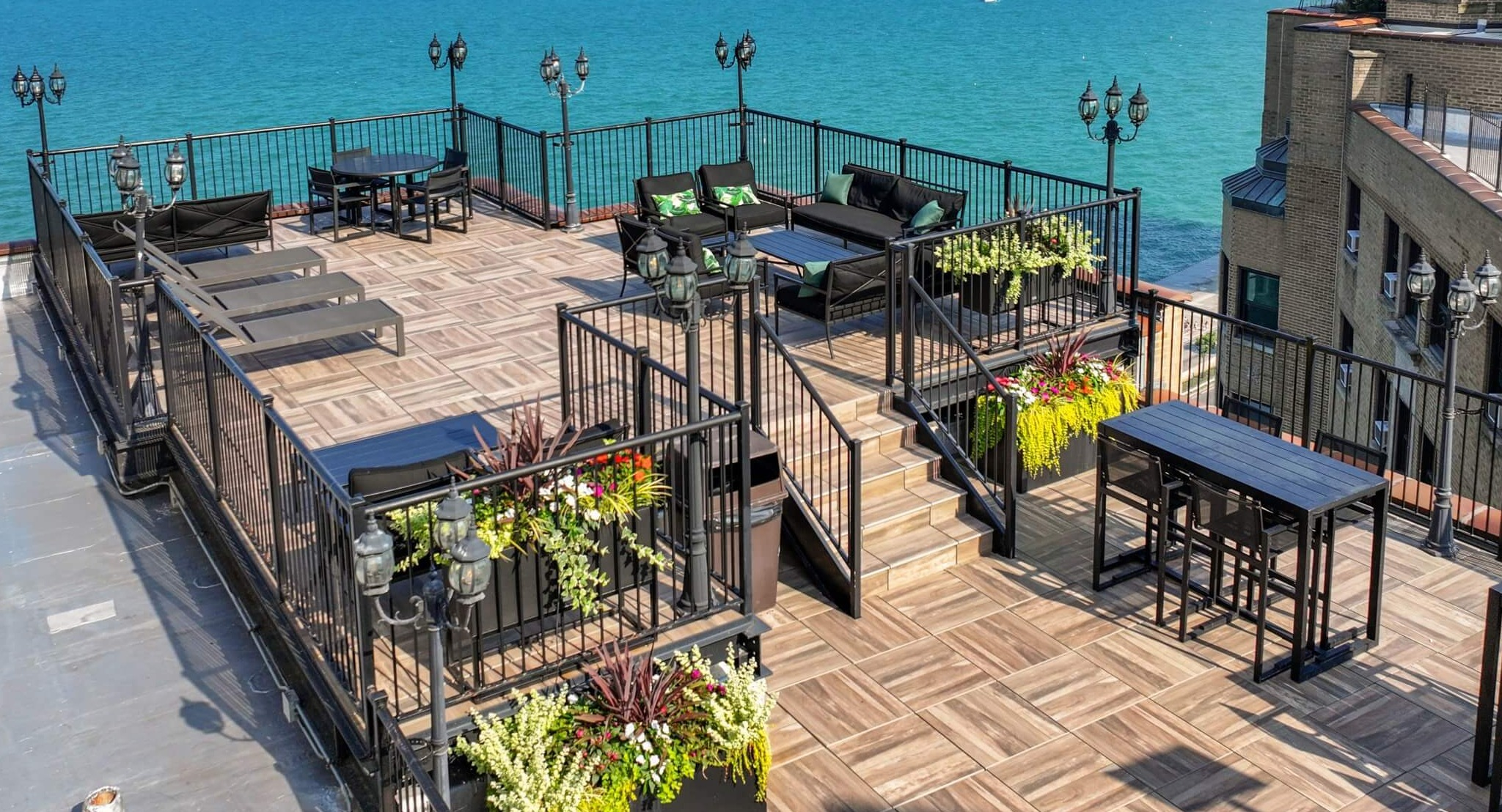 Stunning panoramic lakefront terrace with ample seating, dining tables, and breathtaking views of Lake Michigan and the city skyline at The Deco North Lake Shore in Chicago