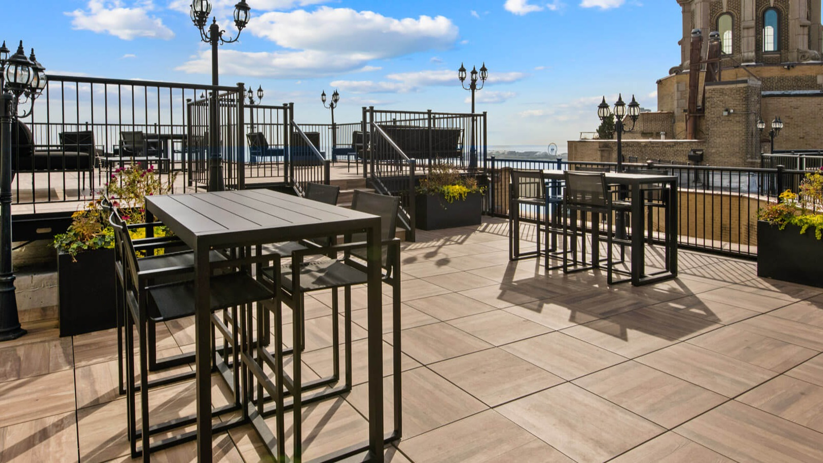 Expansive rooftop dining area with various seating options, ambient lighting, and panoramic views at The Deco North Lake Shore in Chicago