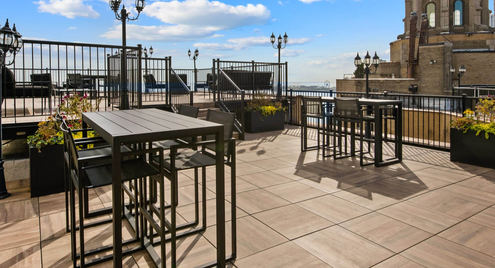 Expansive rooftop dining area with various seating options, ambient lighting, and panoramic views at The Deco North Lake Shore in Chicago
