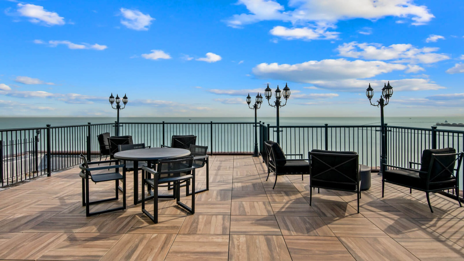 Elegant rooftop seating with contemporary furniture, charming lampposts, and stunning views of Lake Michigan at The Deco North Lake Shore in Chicago
